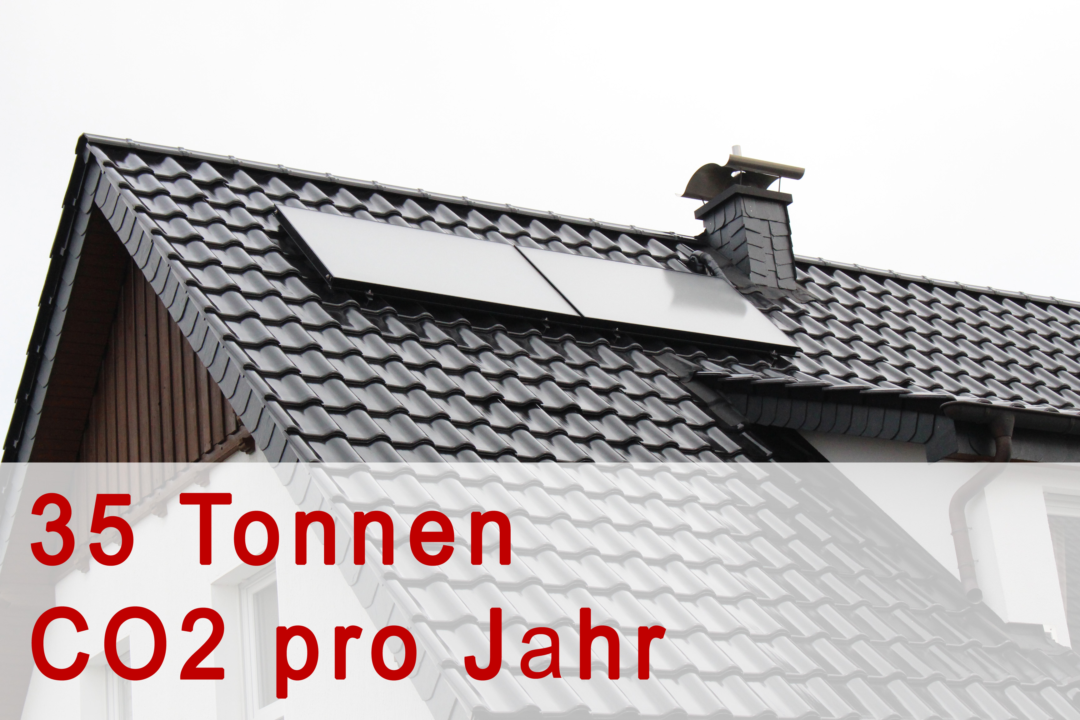 Solarkollektoren auf einem Wohnhaus mit Information zur CO2-Einsparung
